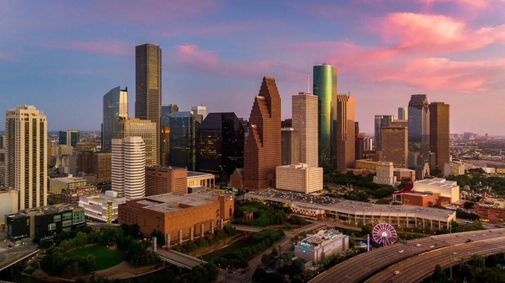 Downtown Houston skyline beneath pink clouds at sunset