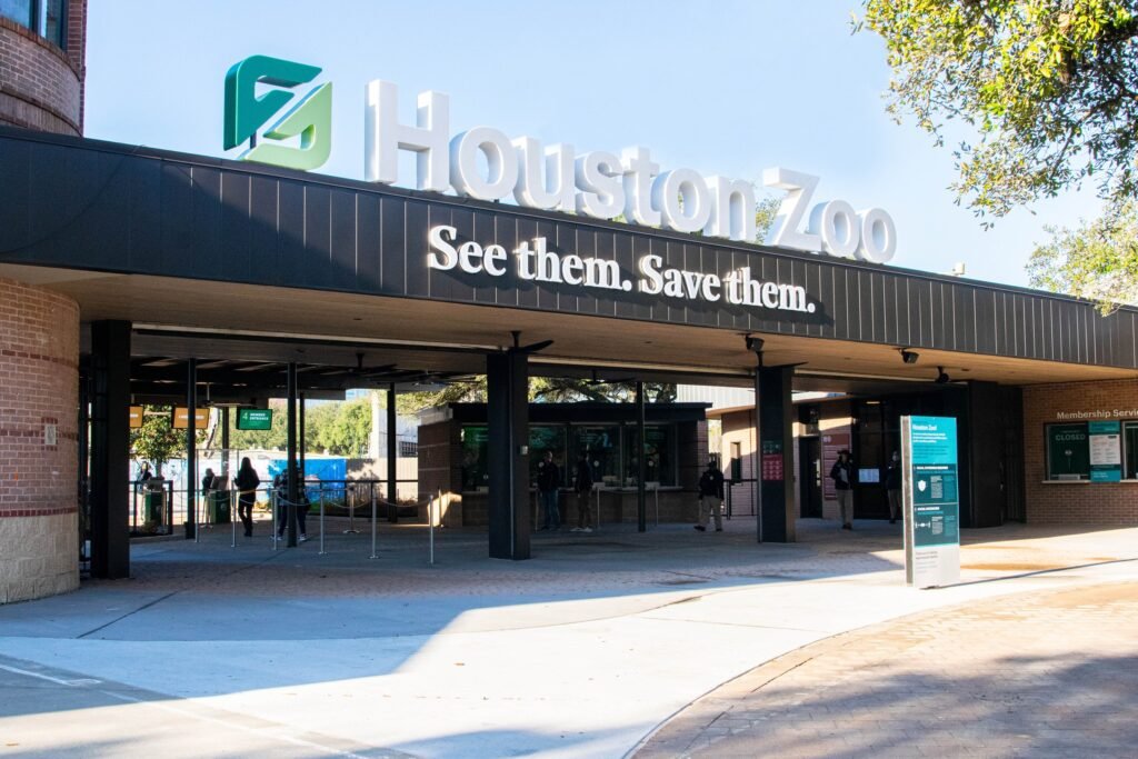 The Houston Zoo's main entrance canopy and ticket plaza on a sunny day in Hermann Park.