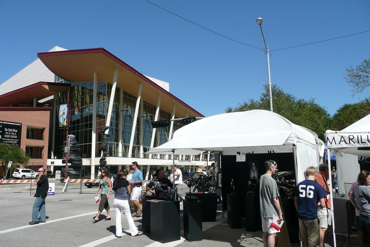 White artist canopy tents and visitors at a prior Bayou City Art Festival downtown near the Hobby Center — licensed historical festival booth atmosphere; not Memorial Park South Picnic Loop and not the October 2026 festival