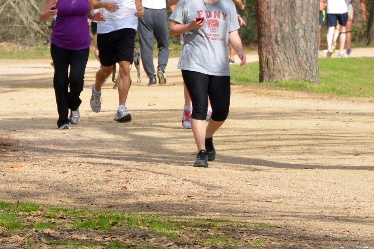 Joggers and walkers on the Seymour Lieberman Exer-Trail through wooded Memorial Park, Houston — licensed everyday park photo for Memorial-area context; not festival grounds or the 2026 Bayou City Art Festival