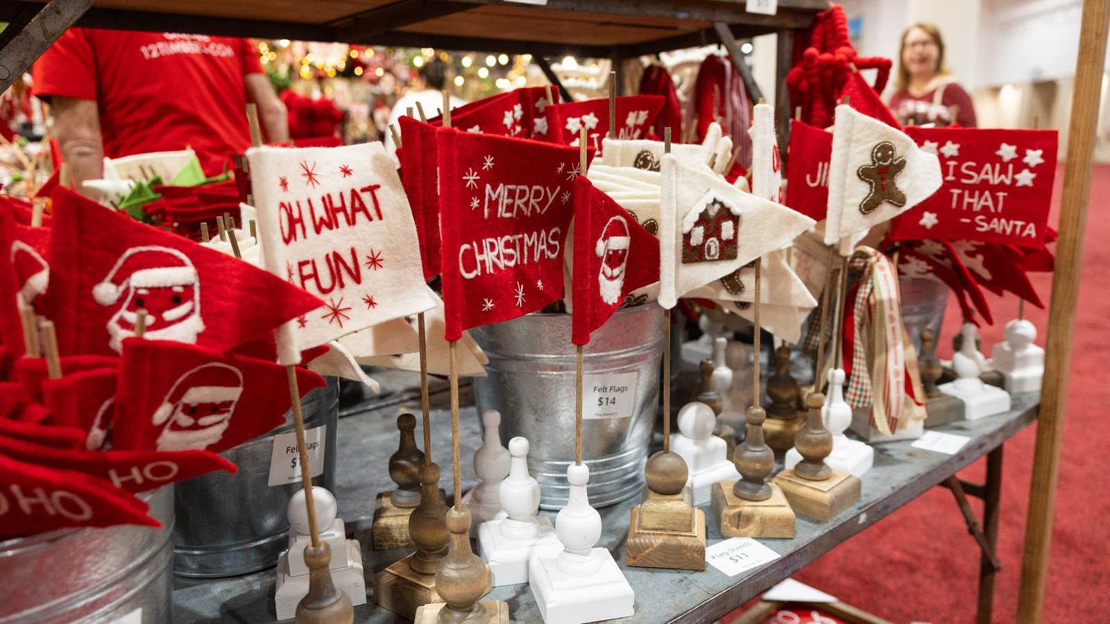 Red and white felt holiday flags on wooden stands at a merchant booth at the 2024 Nutcracker Market